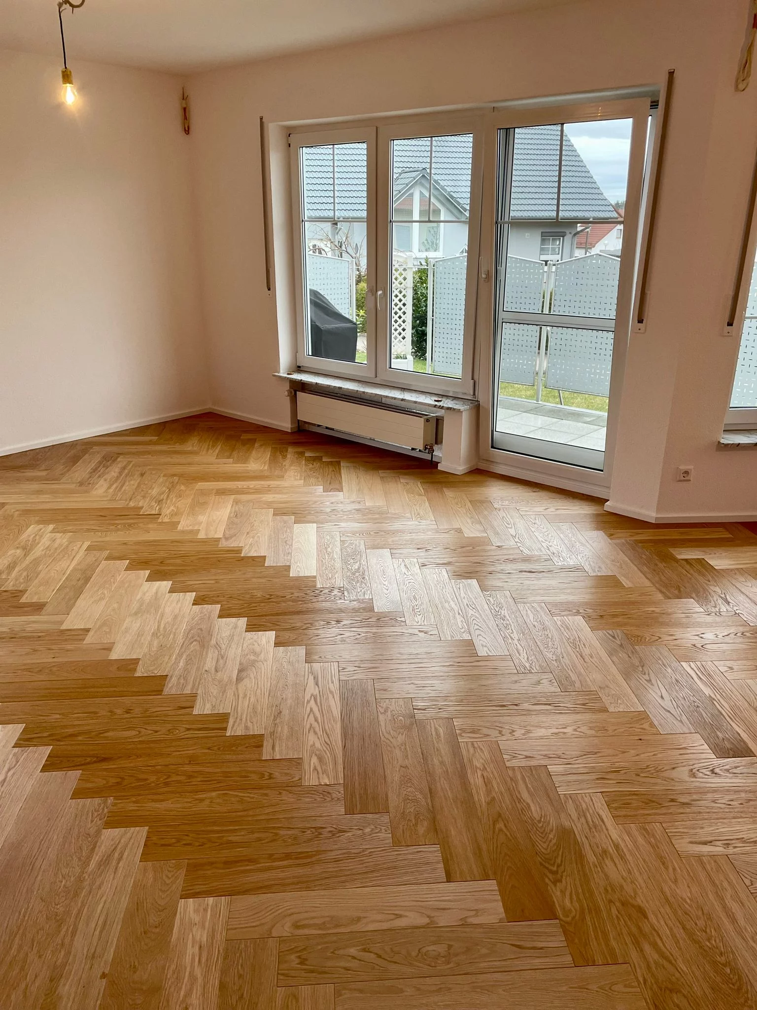 Fertig verlegter Fischgräten Parkett in einem Wohnzimmer